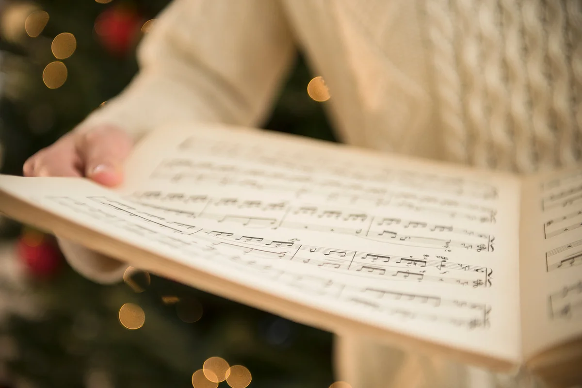woman holding sheet music at christmas