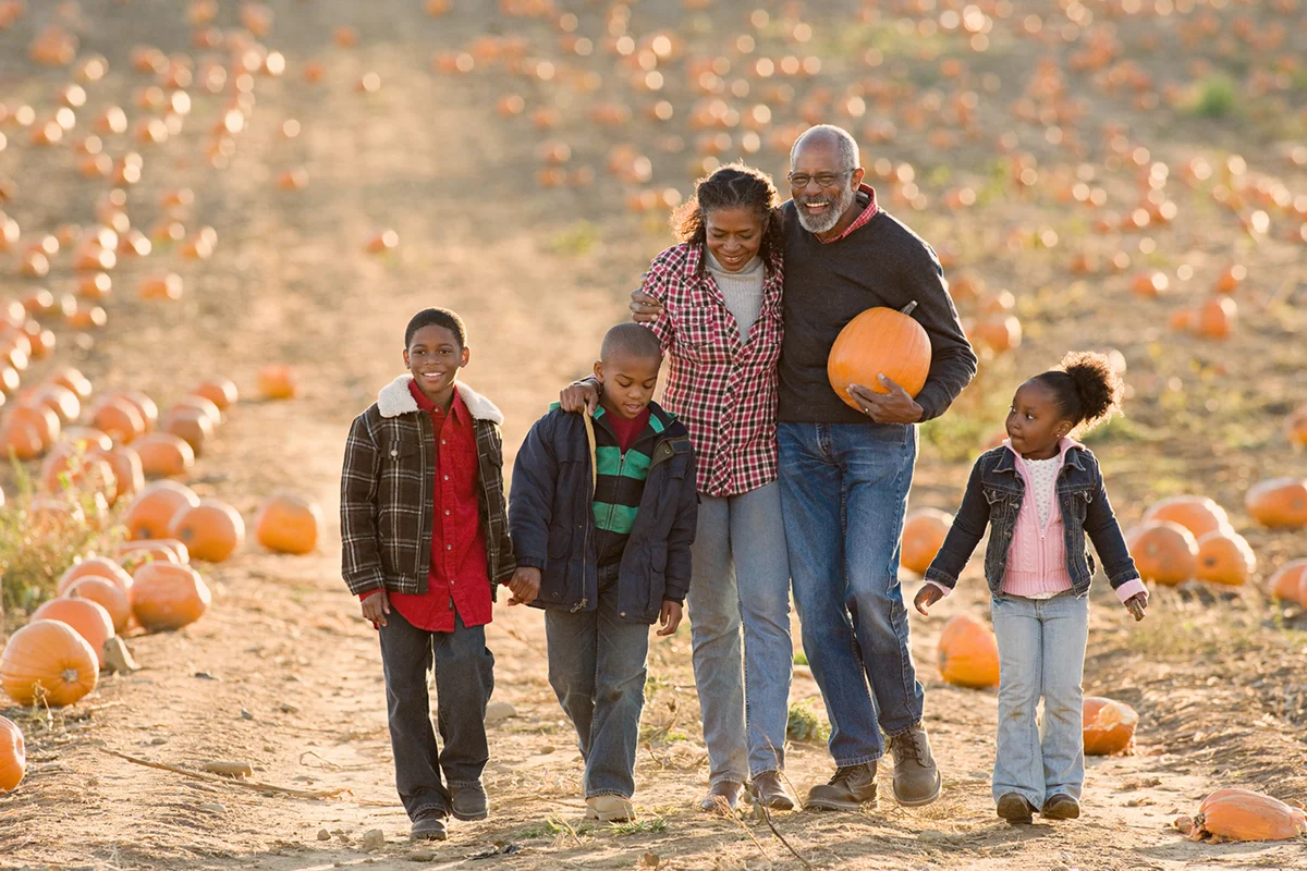 A family walking through a field of pumpkins