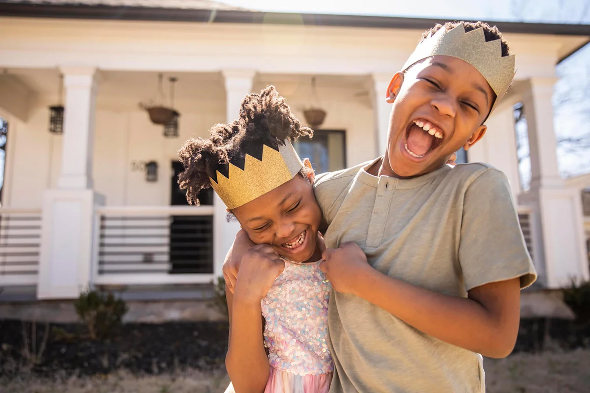 Brother and sister playing outside and wearing homemade crowns