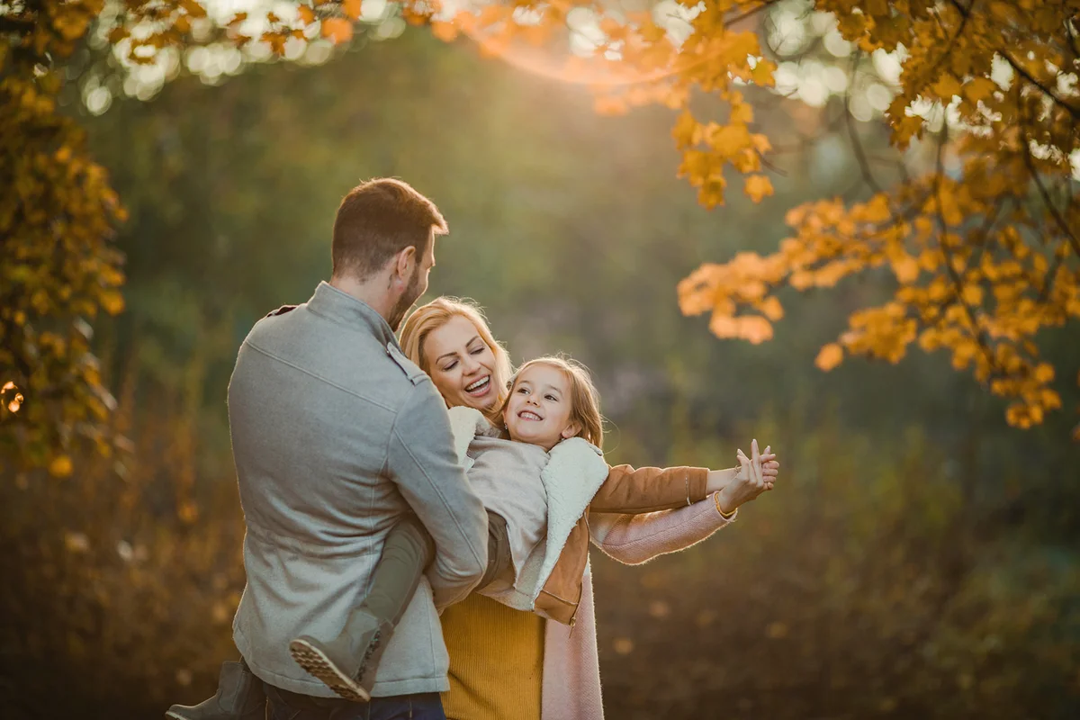 family having fun in autumn season at the park