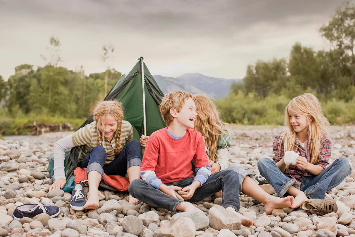 Brother and sisters playing in small tent