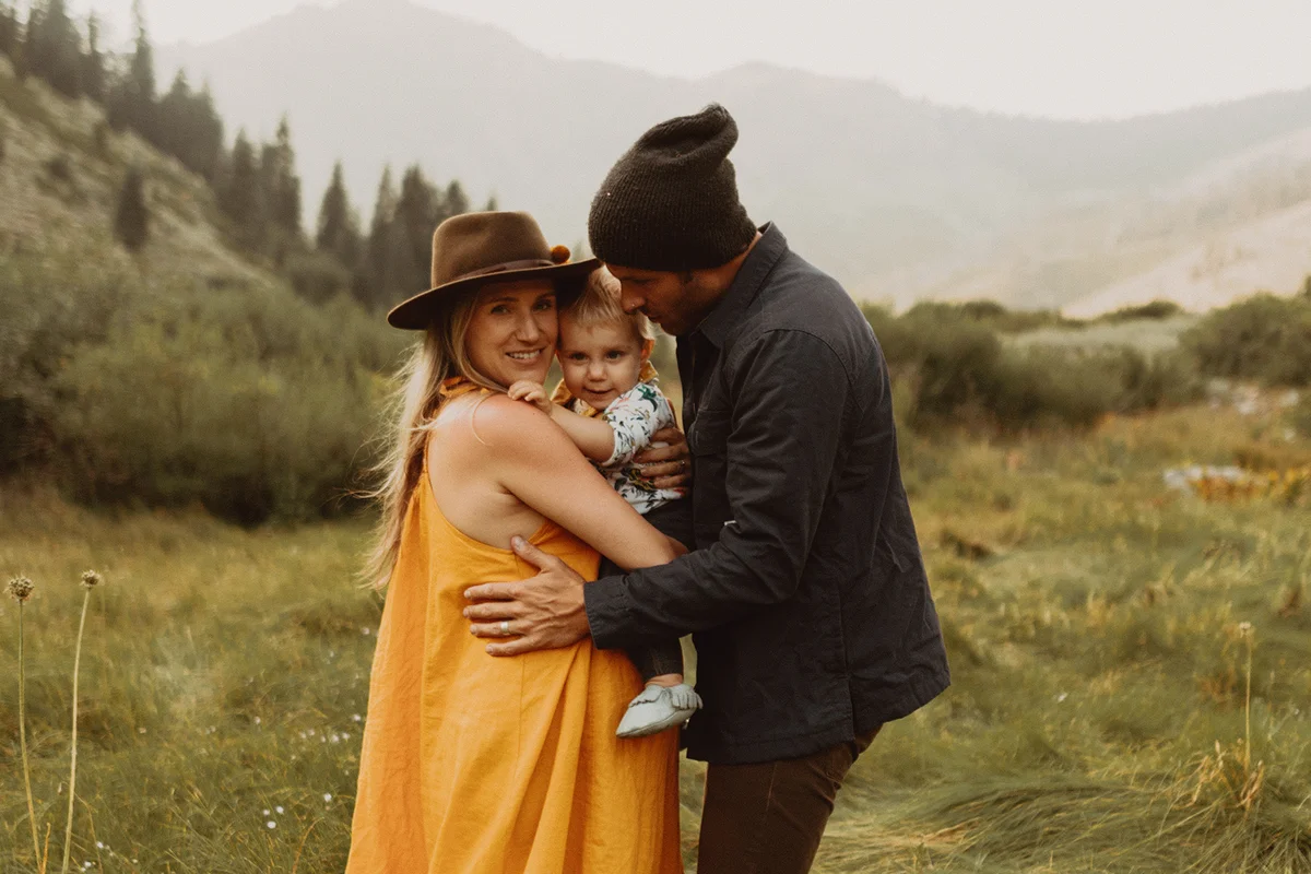 ouple hugging toddler daughter in rural valley