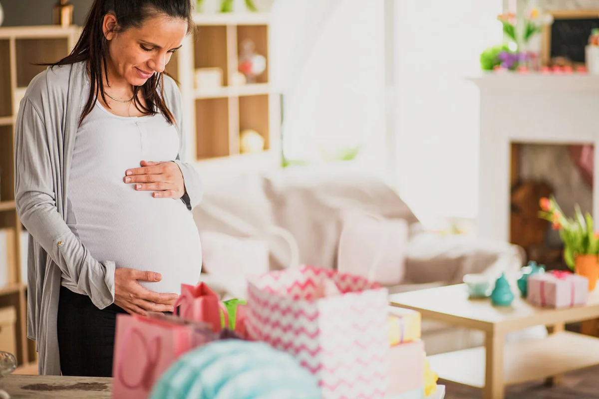 Woman holding pregnant belly on baby shower party