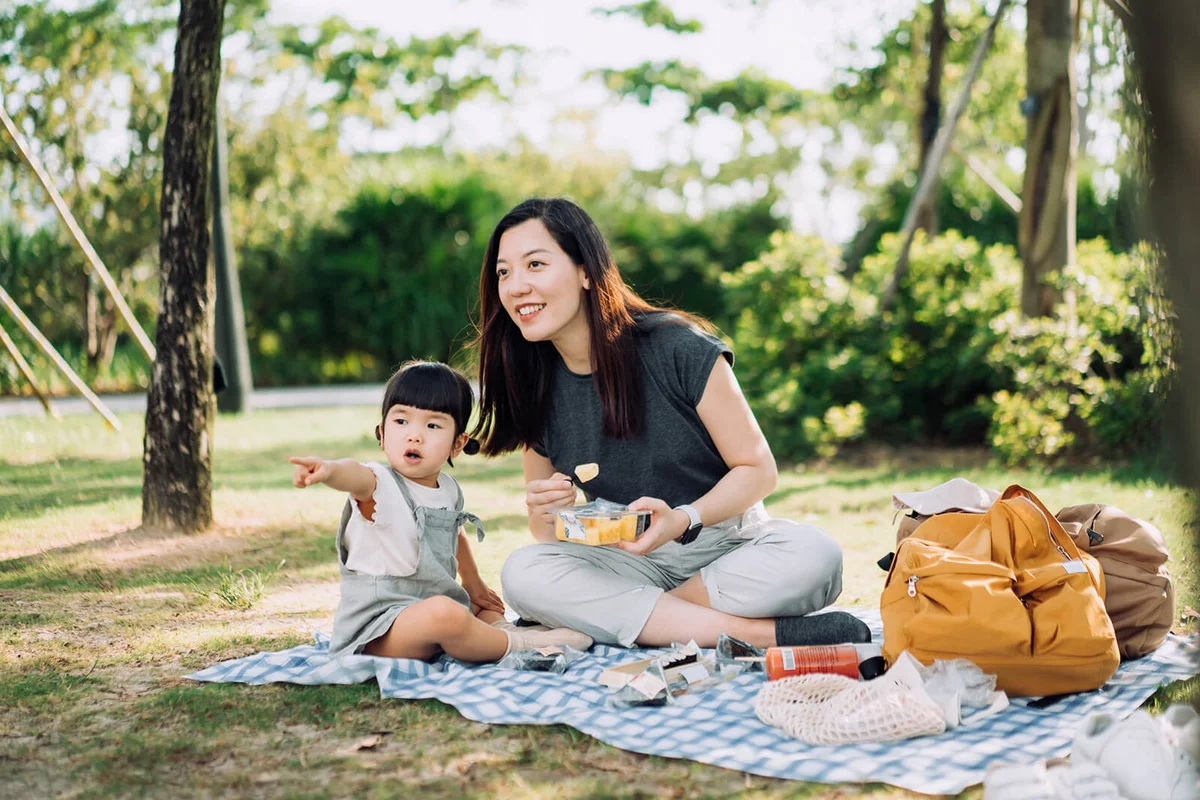 mother and cute little daughter enjoying family bonding time having a picnic on a beautiful day in park