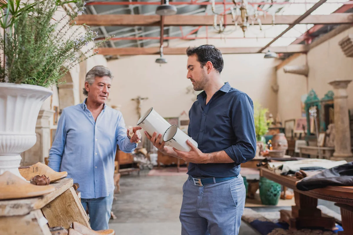 Owner of antique shop talking with customer in his store