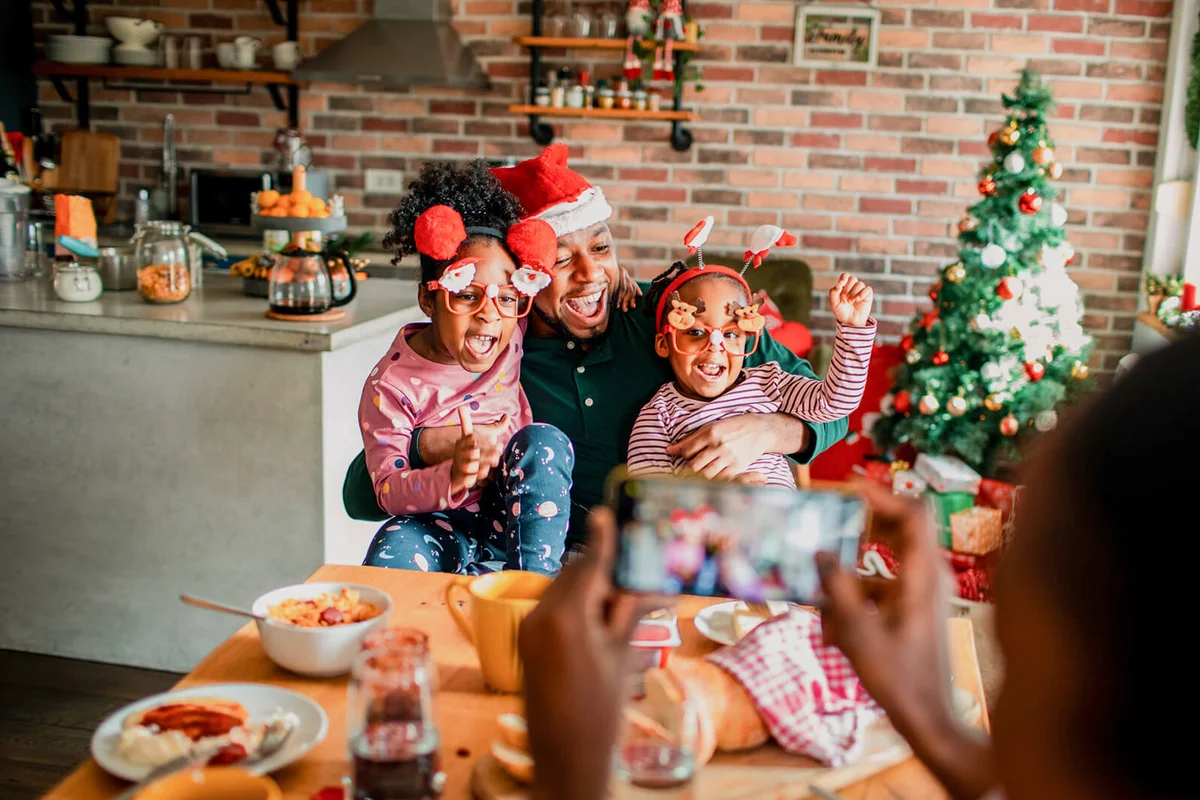 family taking pictures together during breakfast on Christmas