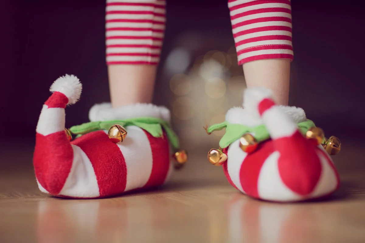 Child wearing Christmas elf novelty slippers with bells
