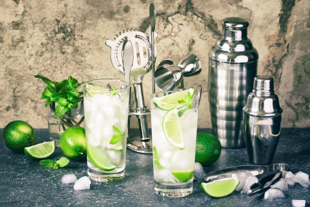Mojito cocktail with lime and mint in glass on a stone table