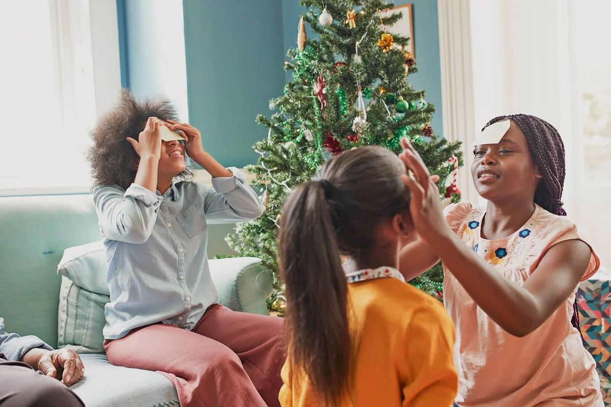 Sisters sticking notes on the forehead at home