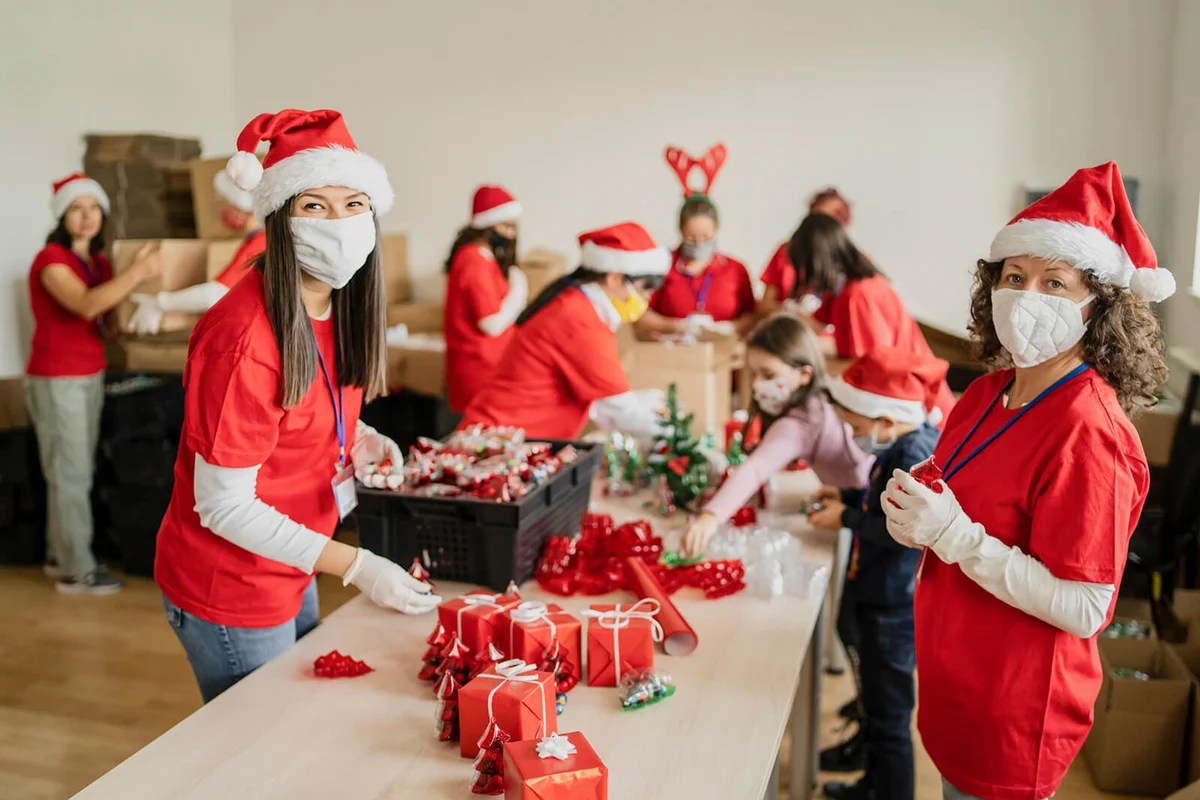 Women volunteering by preparation of Christmas presents for poor people in time of pandemic