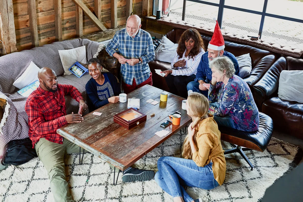 Group of multi racial friends playing games and chatting at Christmas