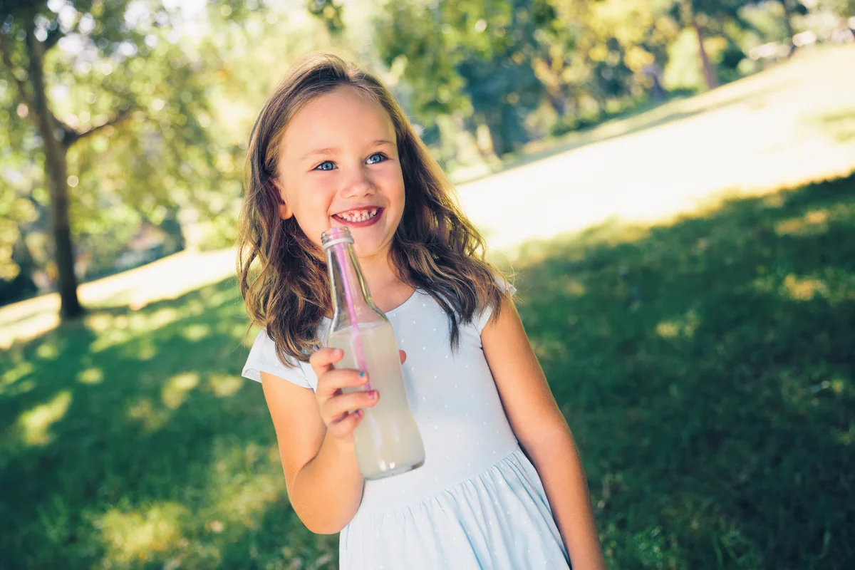 Child with drink in bottle at park