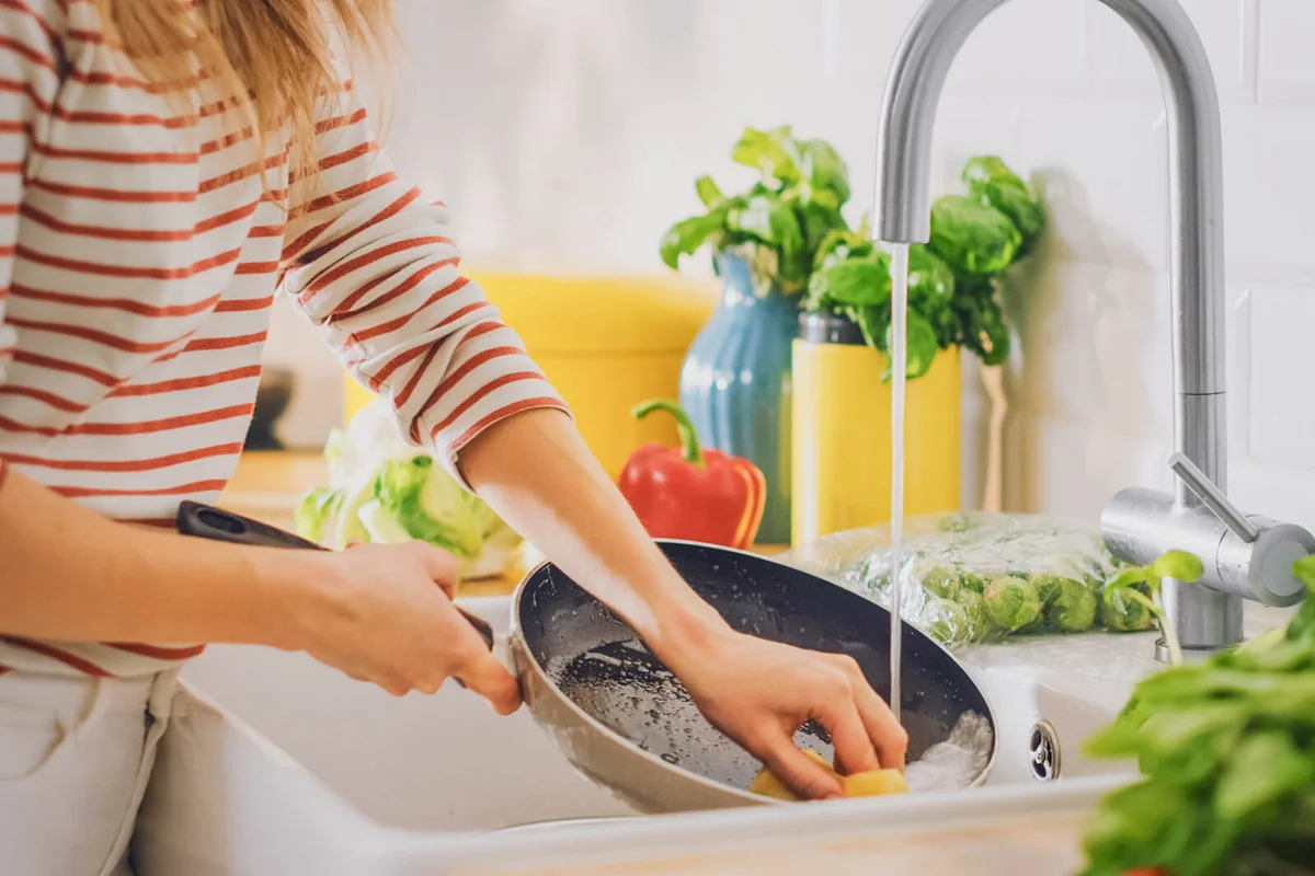 Woman Washing a Frying Pan