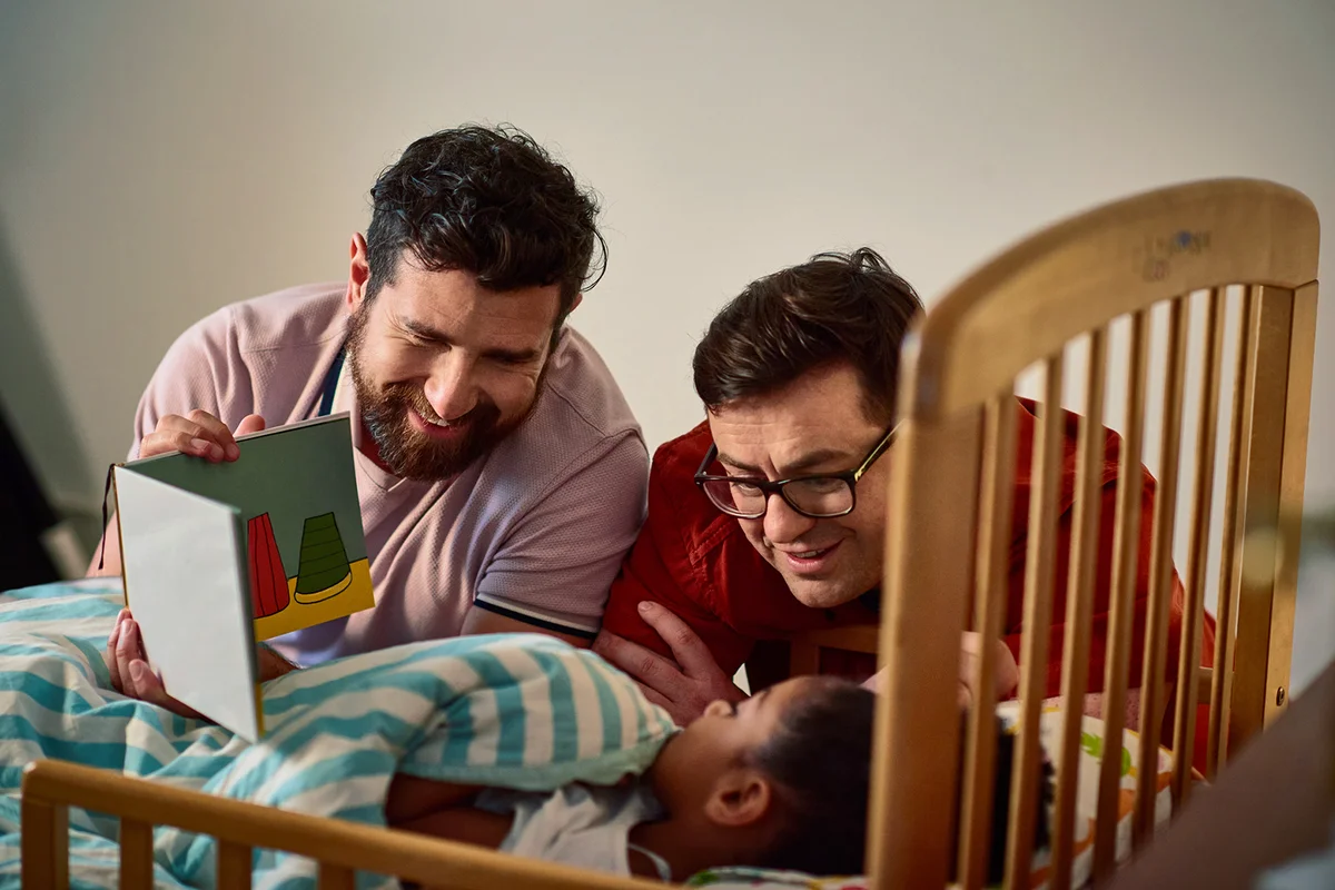 Fathers reading bedtime story to daughter
