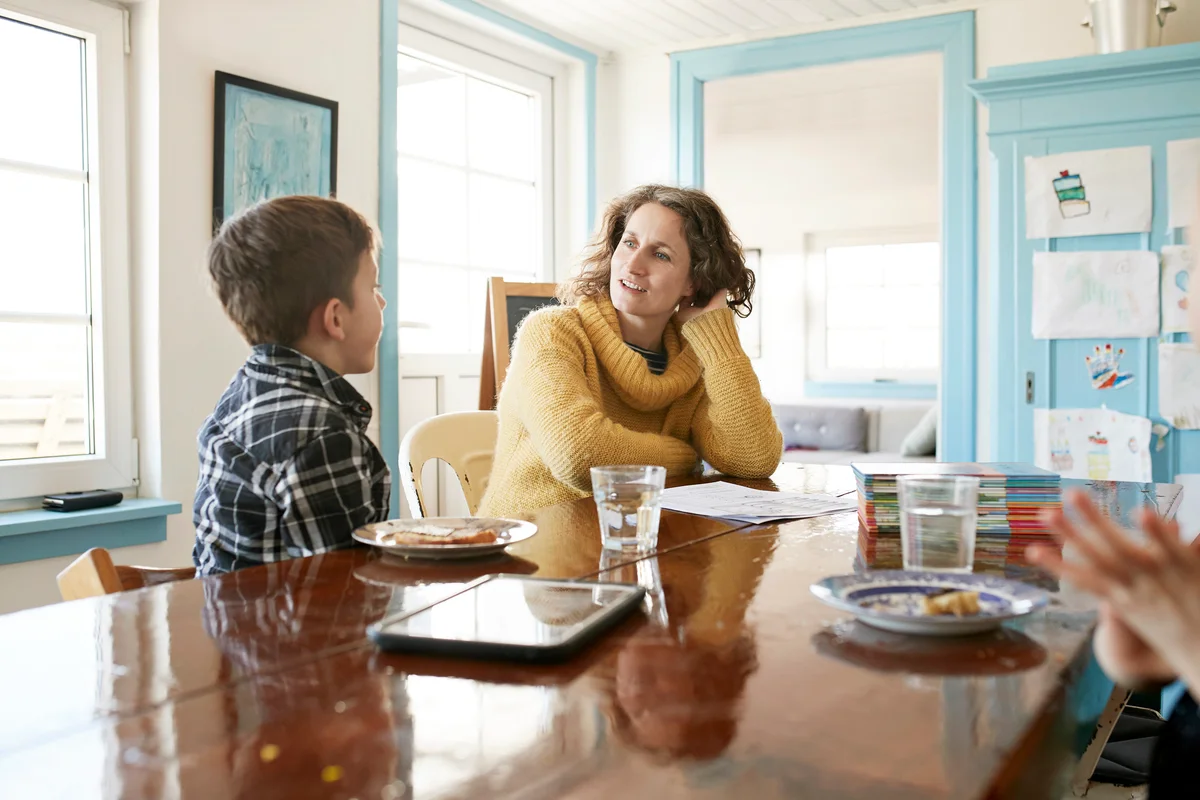 Mother and son eating and talking at dining table