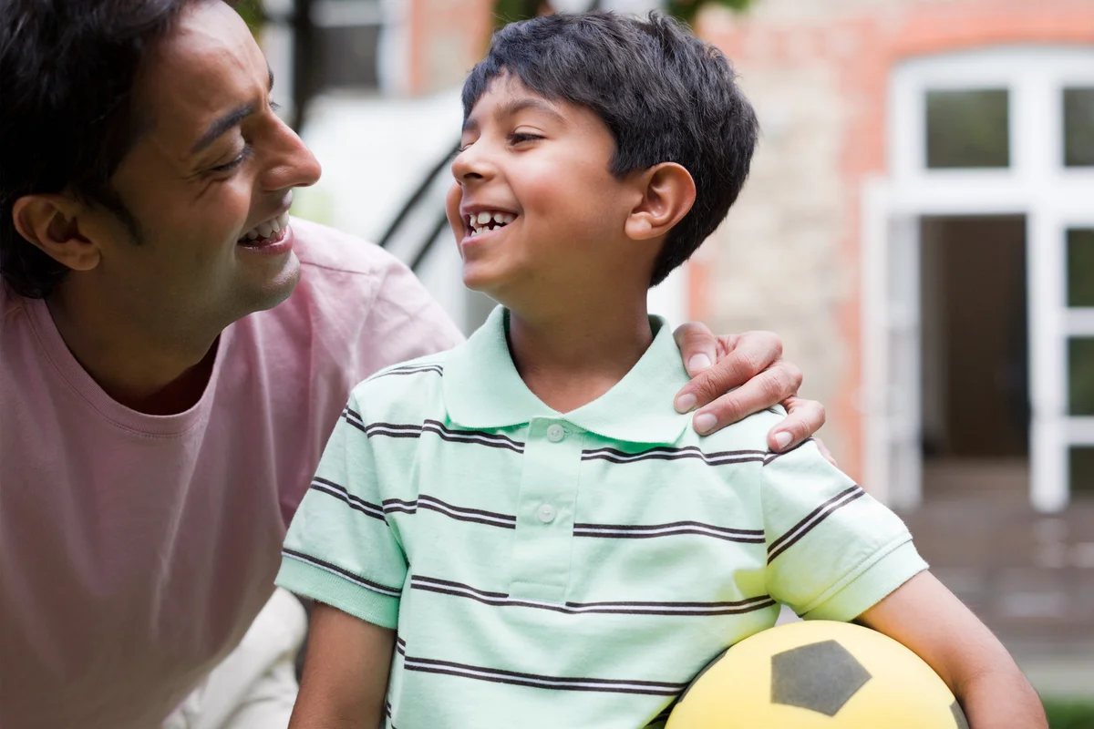 Happy father and son playing soccer