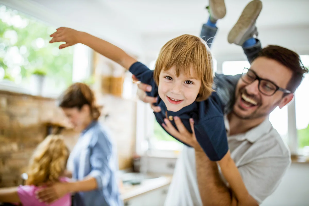 Happy boy having fun with his father in the kitchen