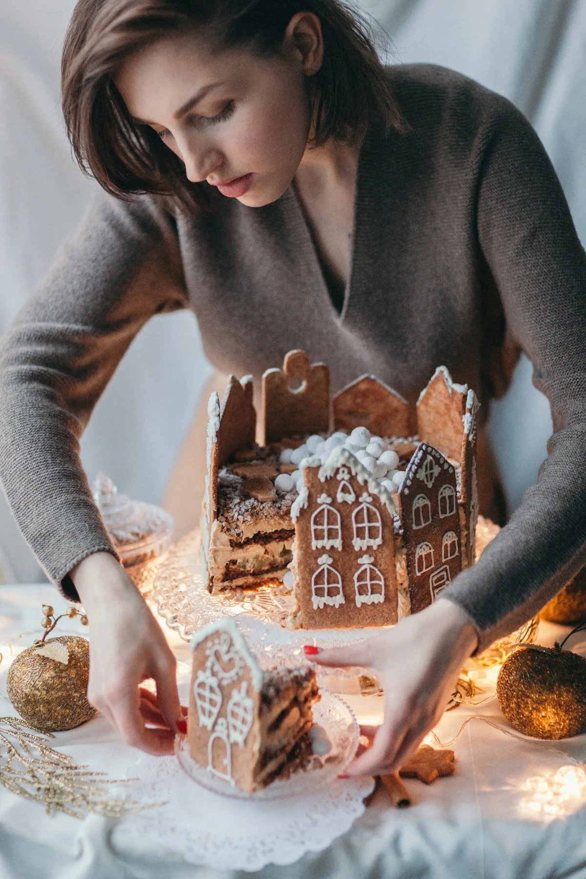 Woman with gingerbread house cake