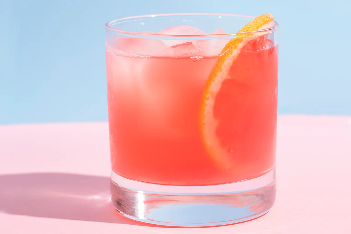 Grapefruit cocktail on pink table and blue wall