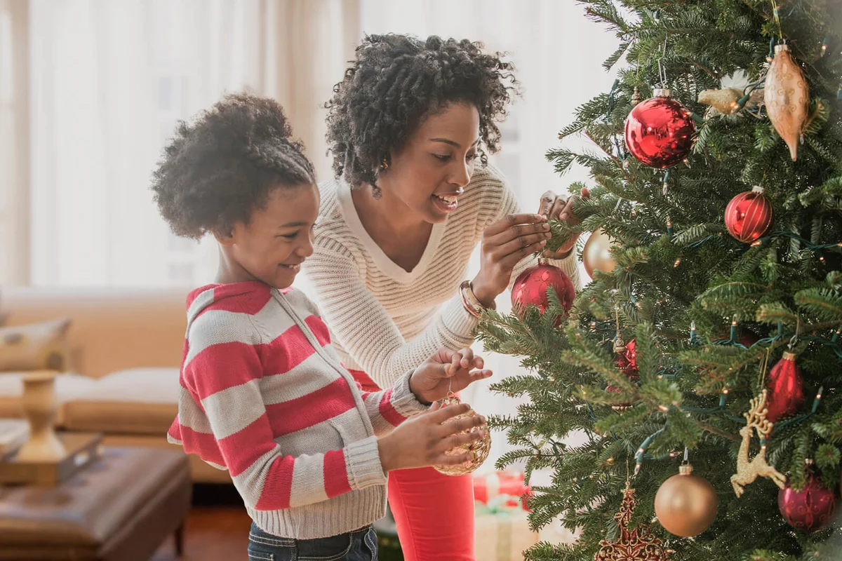 Mother and daughter decorating Christmas tree