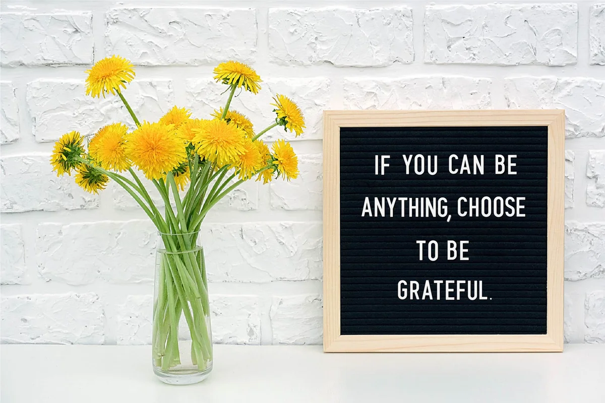 Black letter board and bouquet of yellow dandelions