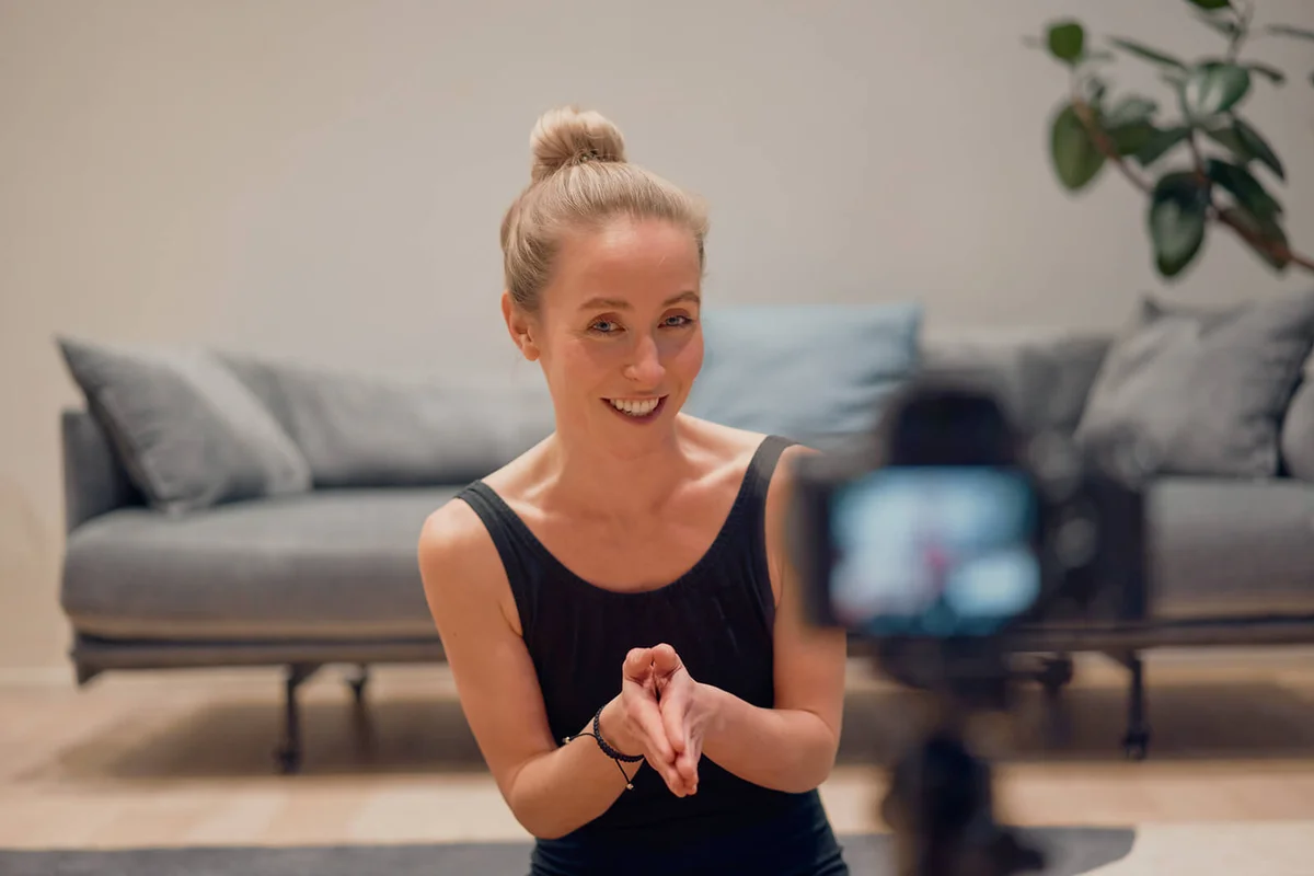 Woman yoga teacher record online course on camera at home