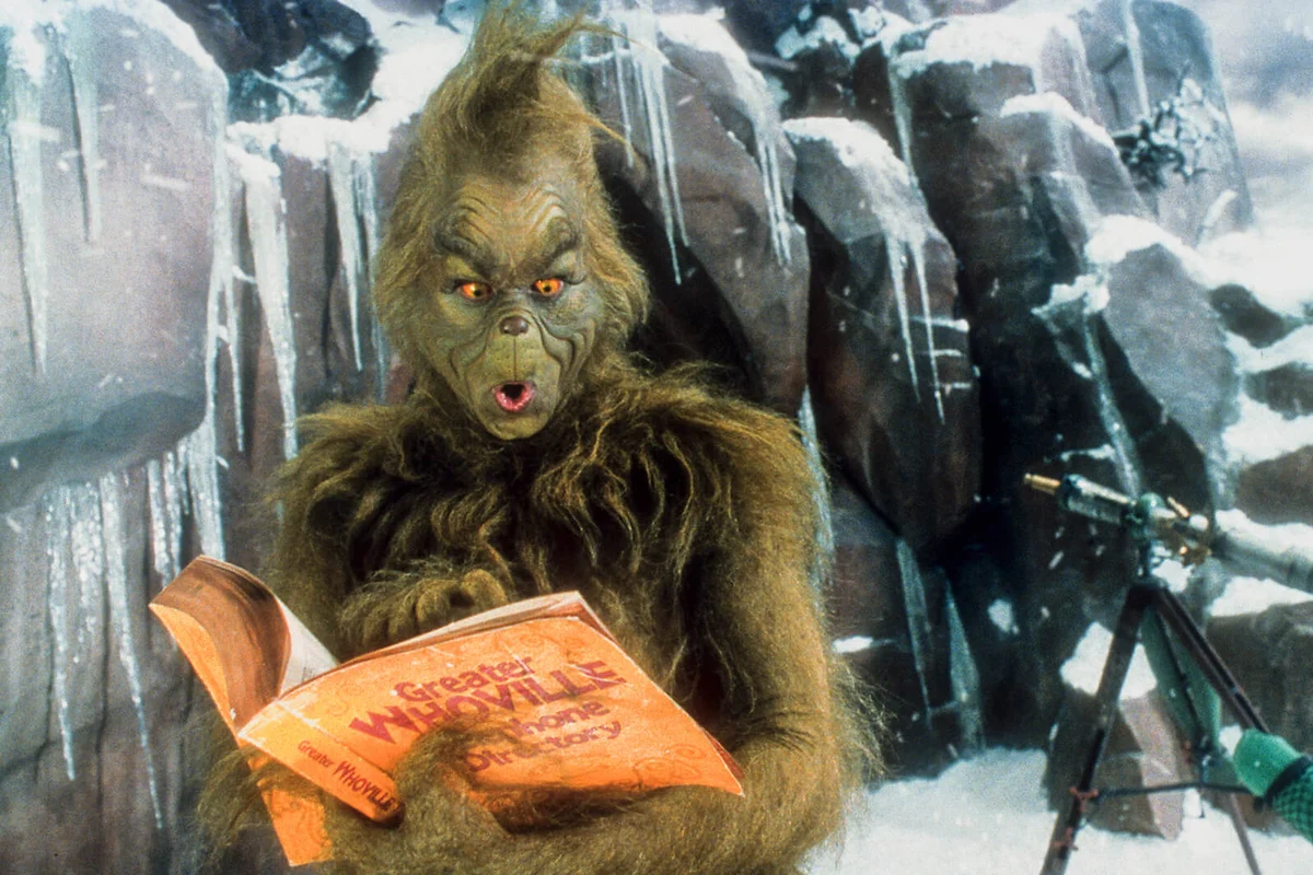Jim Carrey looking through phone directory in a scene from the film 'How The Grinch Stole Christmas', 2000 | Getty Editorial Use