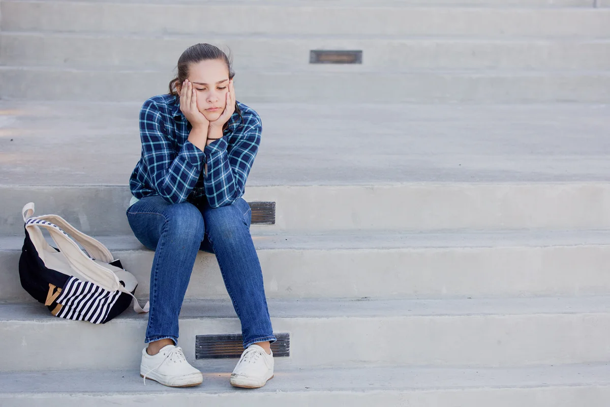 Bored Young Woman With Backpack Sitting On Steps