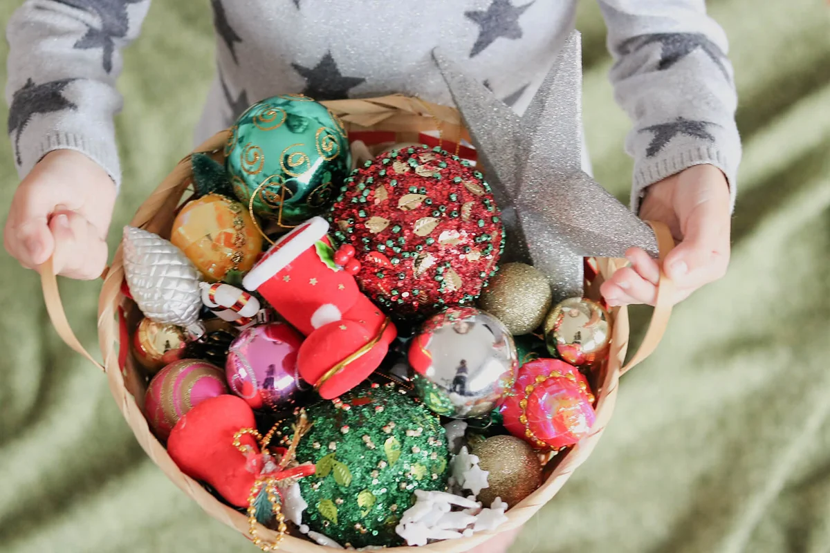Person holding Christmas ornaments in basket