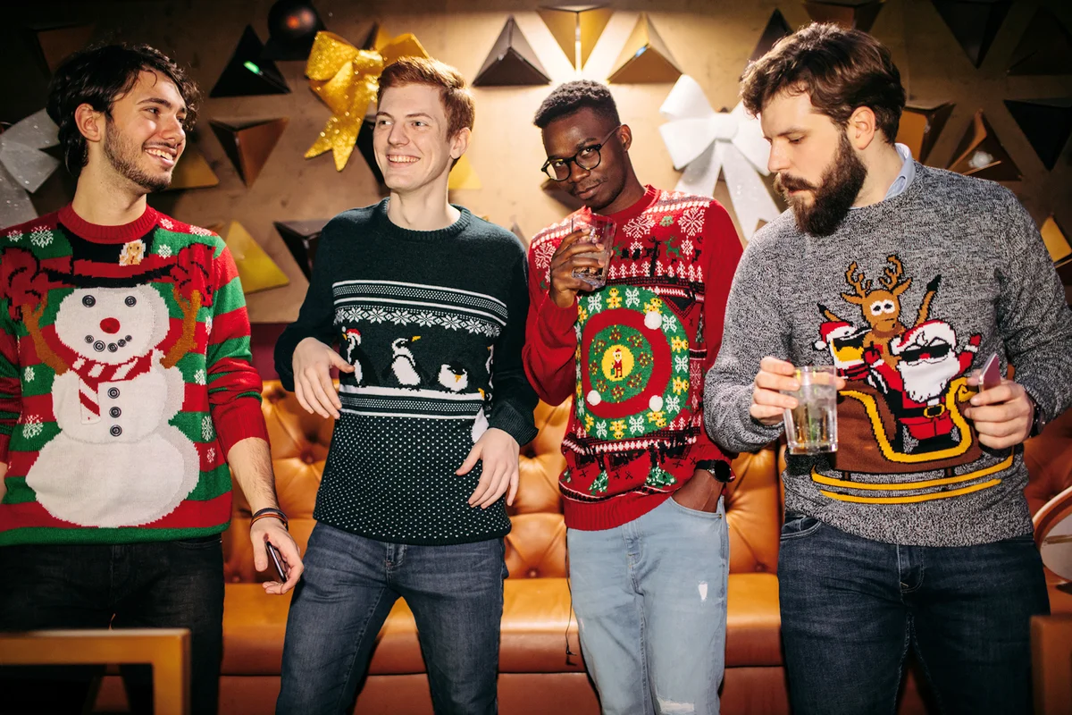 Cheerful Friends Having Fun In Nightclub Wearing Christmas Sweaters