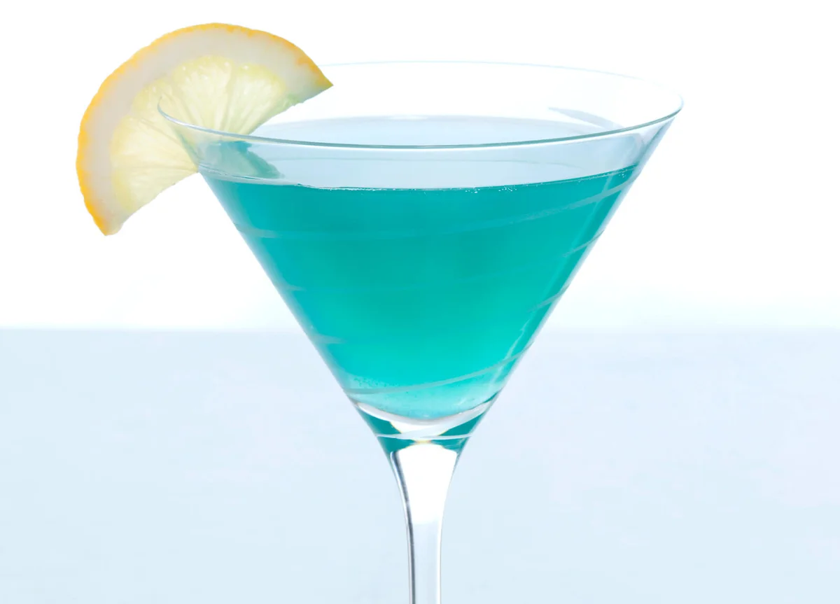 Blue cocktail with lemon wedge