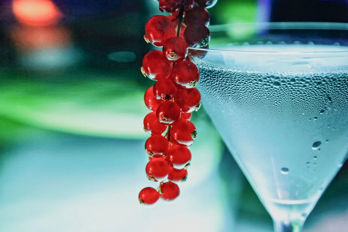 Blue iceberg' in glass with red currants on edge
