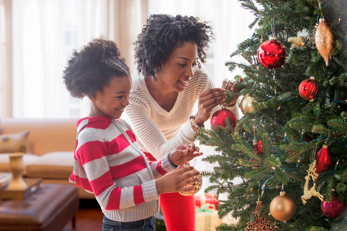 Mother and daughter decorating Christmas tree