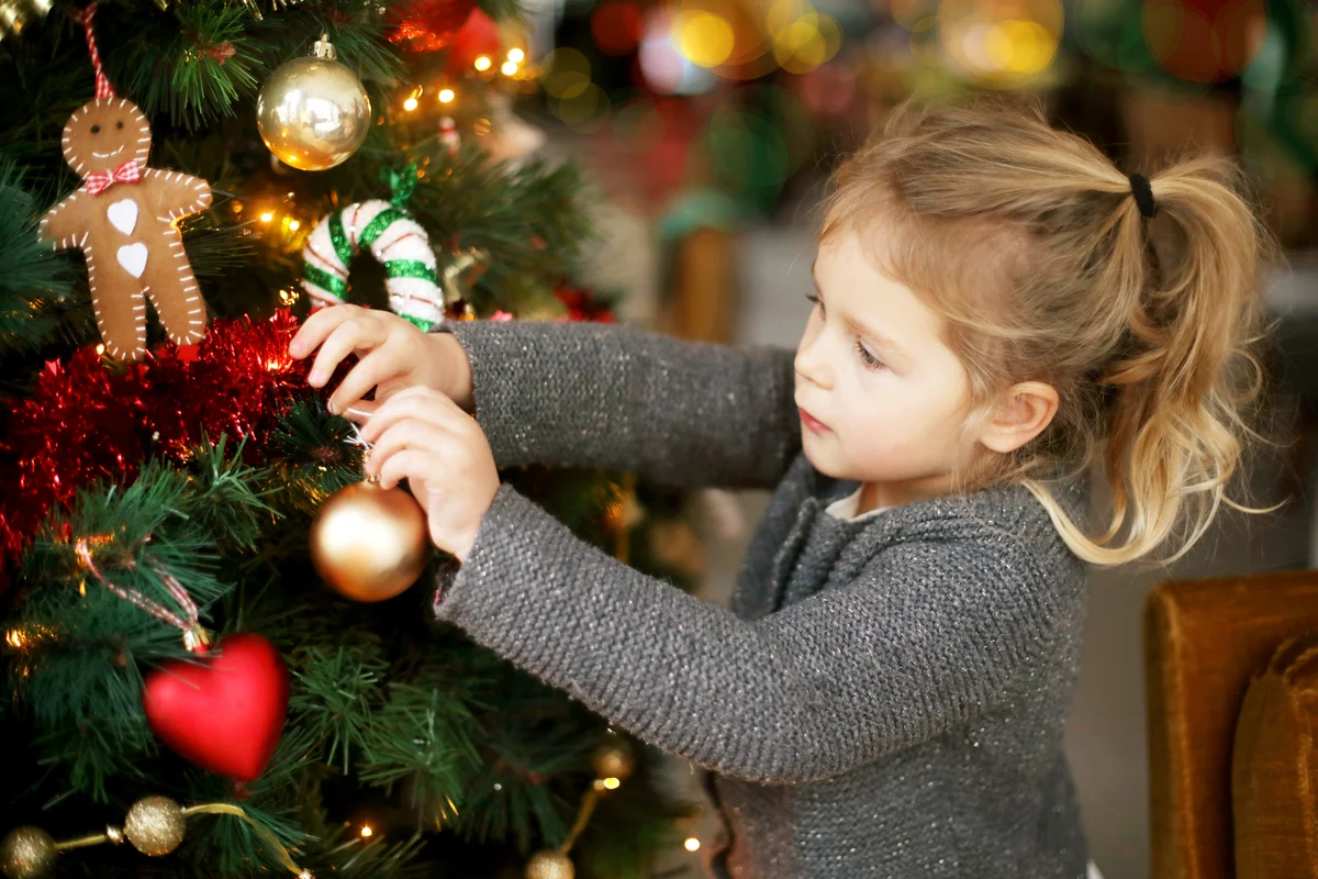 Little girl holding a Christmas tree bauble