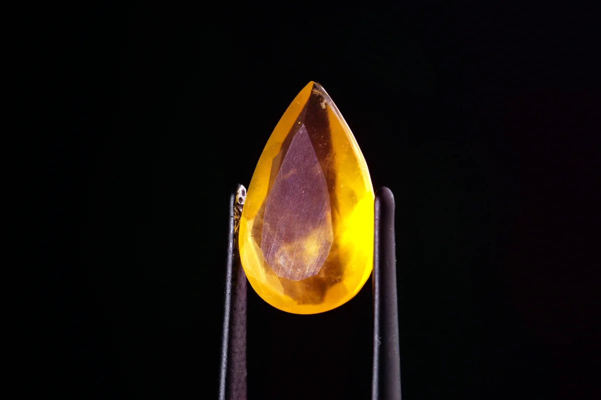 Fire opal in tweezers