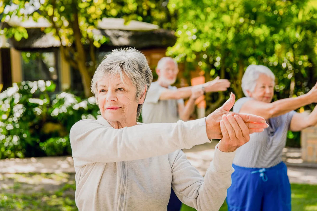 Senior woman with friends exercising in yard