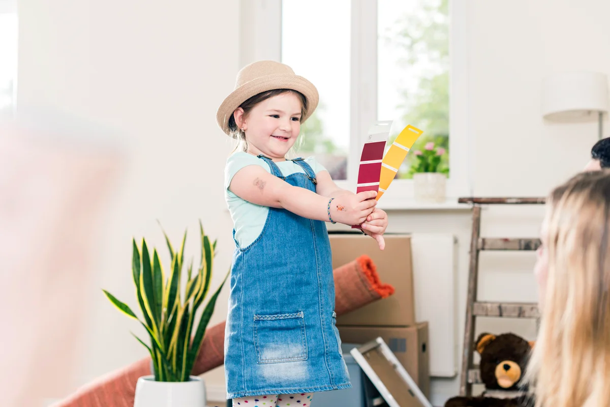 Girl showing color sample to parents in new home