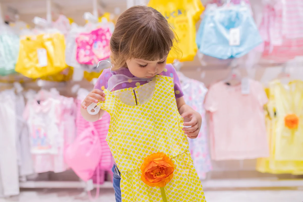 Adorable smiling little girl at the clothes store