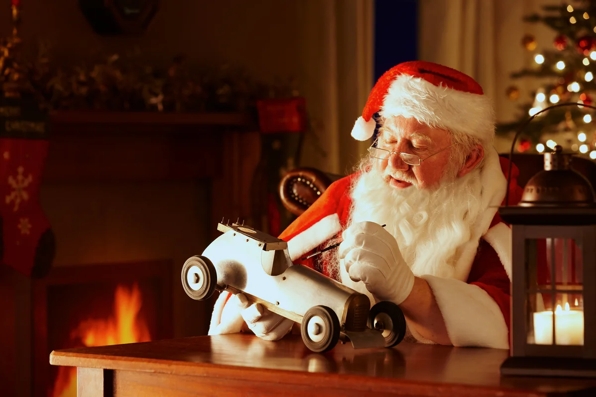 Santa painting a toy car in his workshop