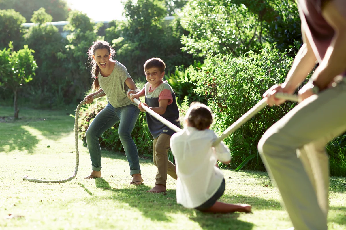Family playing tug-of-war in park