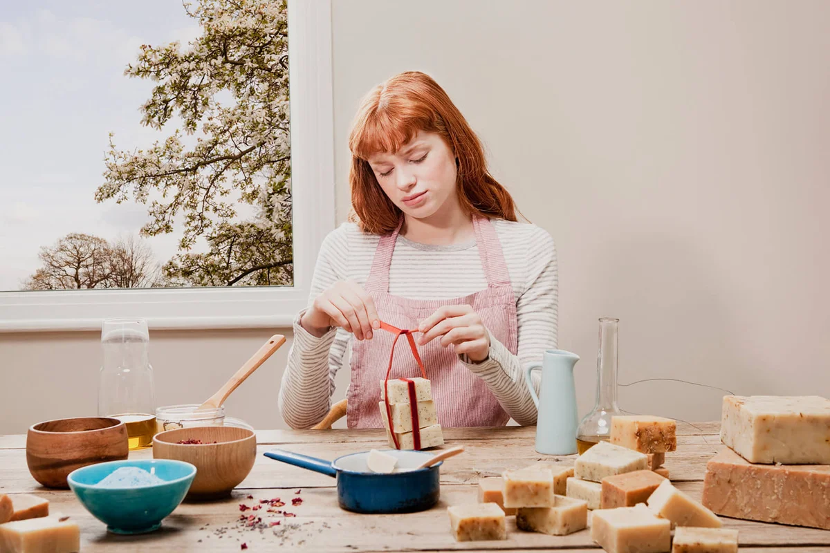 woman putting ribbon around soaps