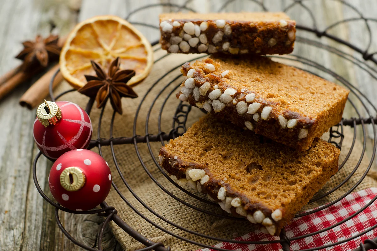 Gingerbread cake with christmas baubles and dried orange, spice on wooden table,