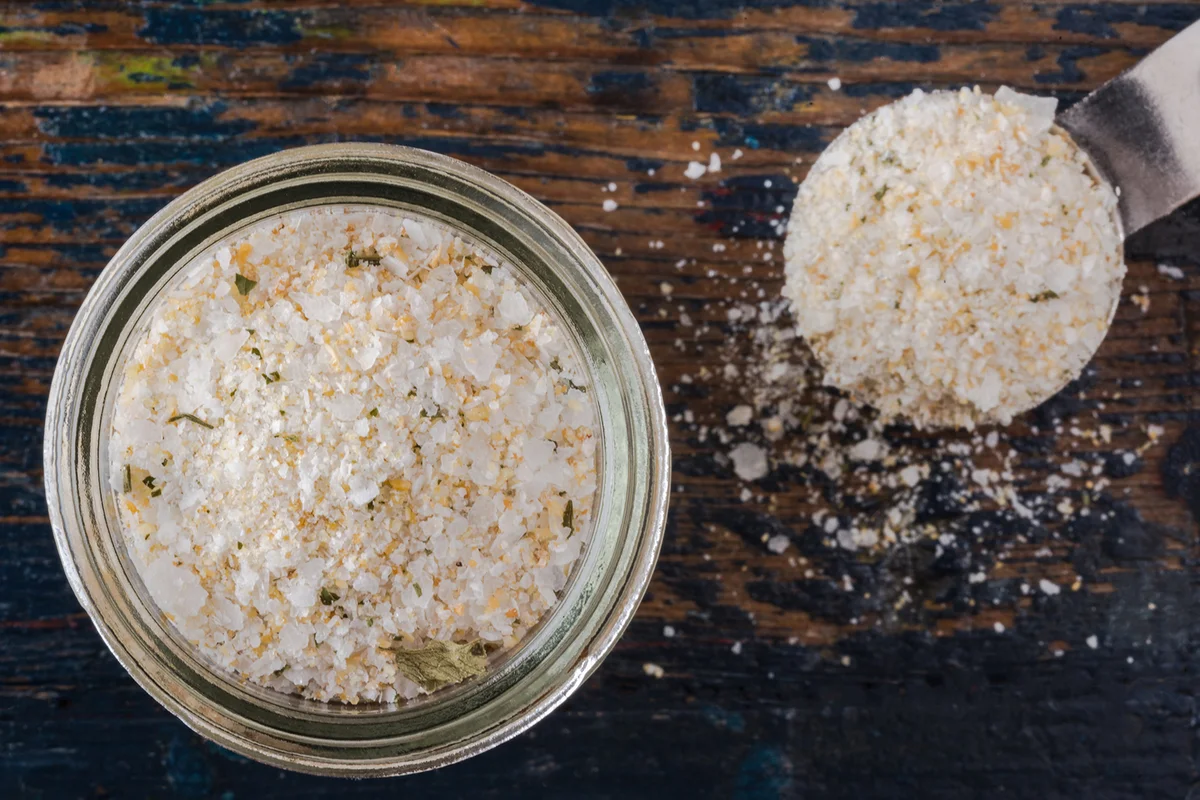 Grounded Garlic With Salt In Jar By Spoon On Wooden Table