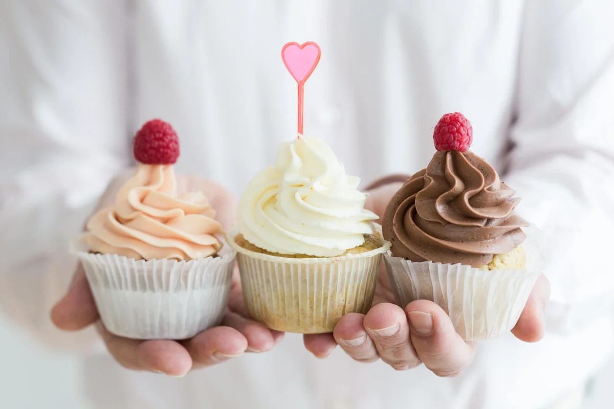 Cupcakes with buttercream frosting held by a man