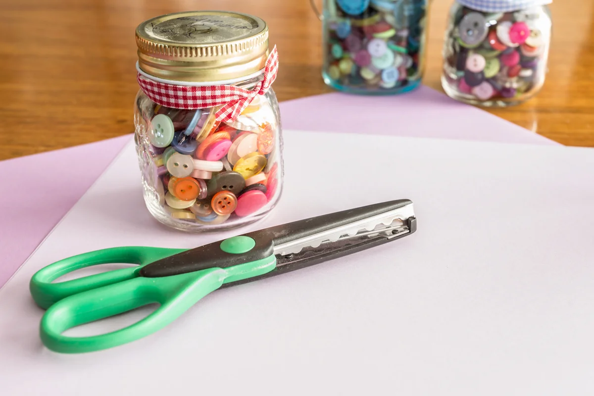 Pair of scissors and buttons on craft paper