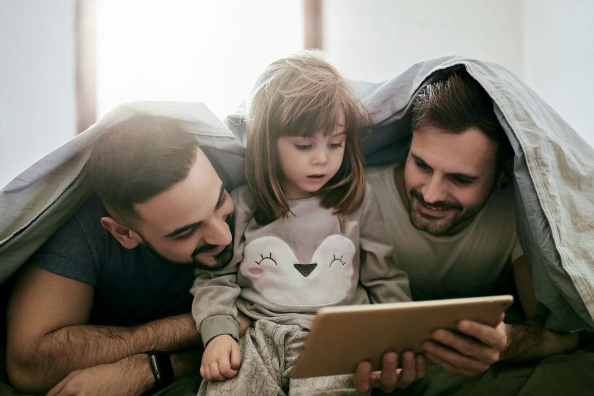 Girl watching movie with parents on digital tablet