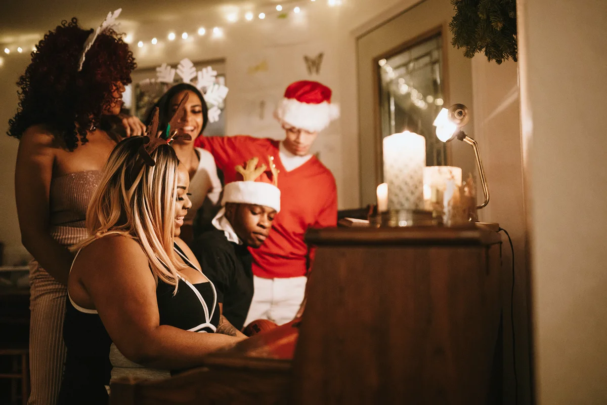 Friends Christmas Party Singing At Piano