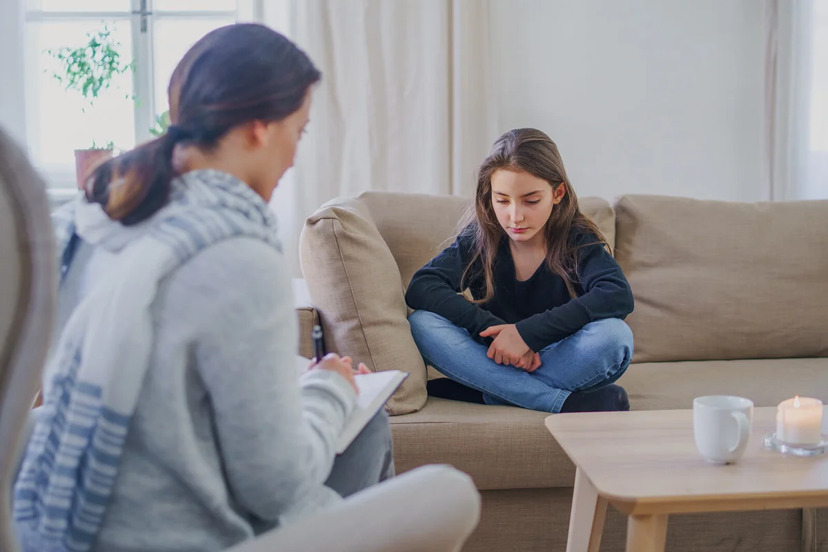 Sad and depressed small girl with therapist