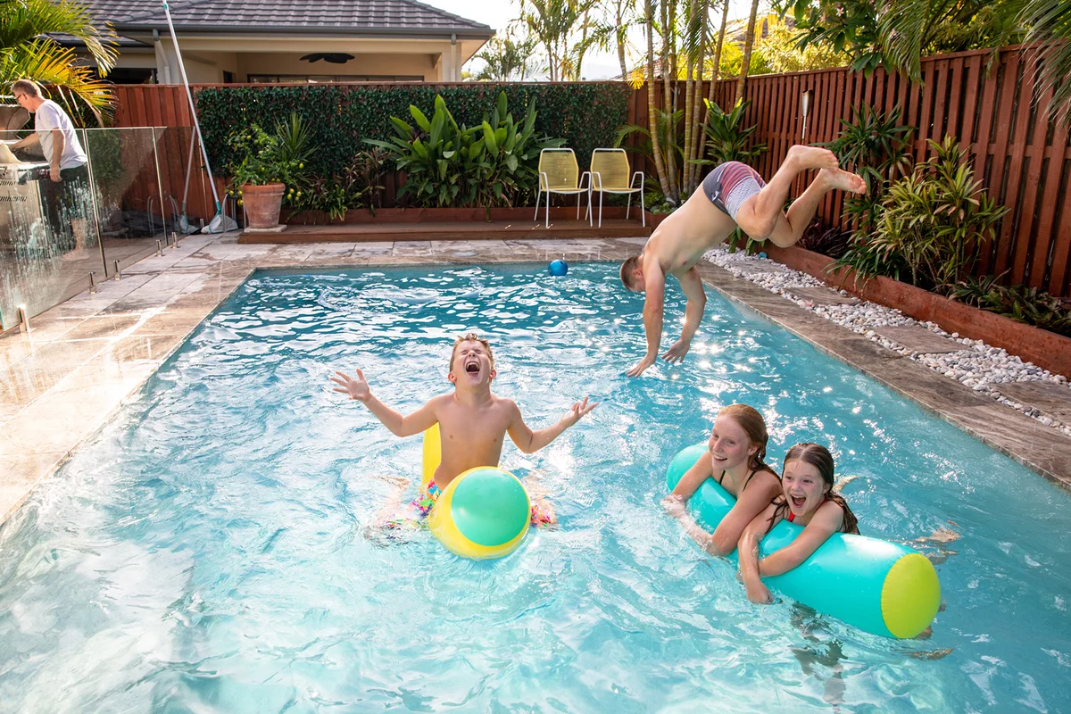 family plays in swimming pool