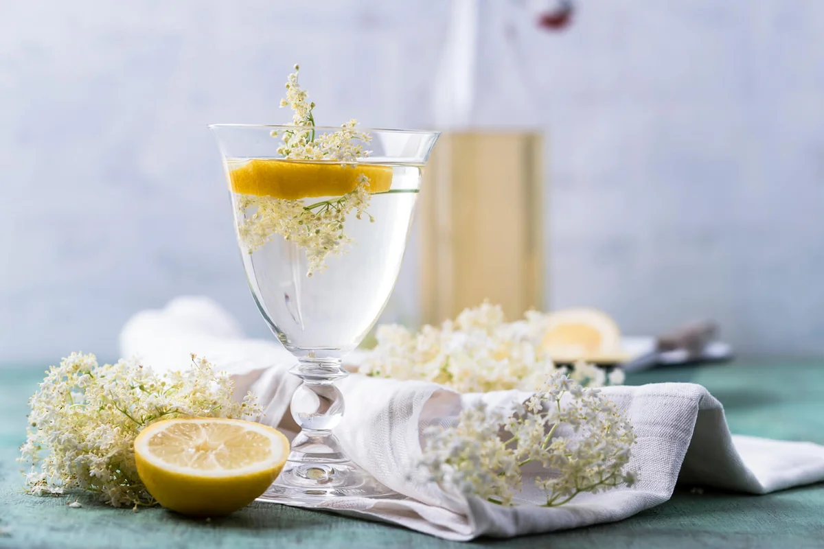 Glass of water flavoured with elderflower sirup and lemon